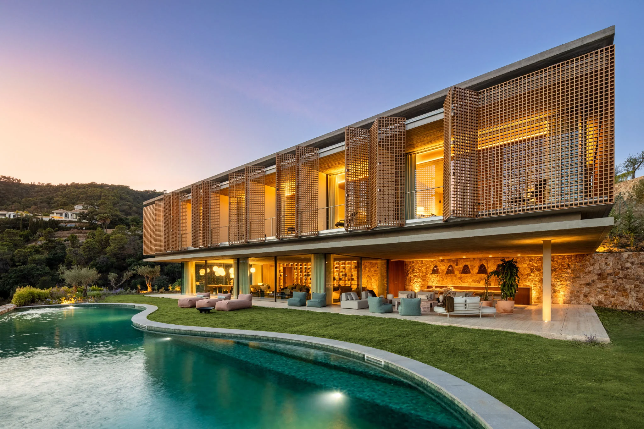 Villa Alia at dusk with an illuminated facade and swimming pool